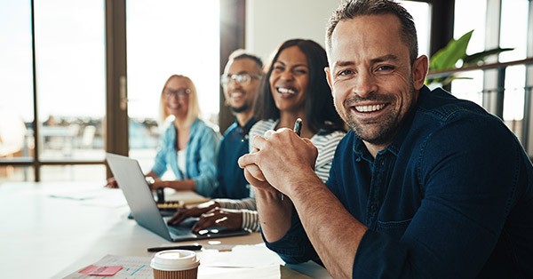 Group of employees sitting at a table smiling