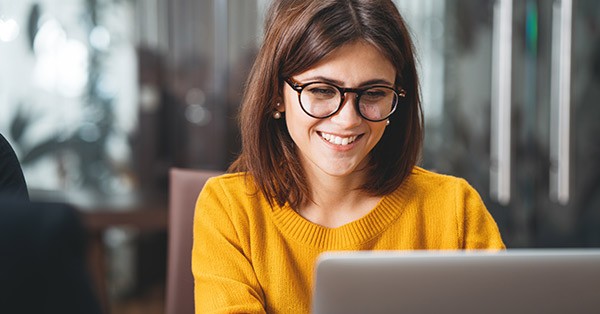 Woman sitting at desk in front of laptop monitor