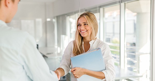 Smiling woman standing and shaking hands