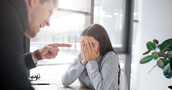 Stressed out woman with her boss pointing is finger at her