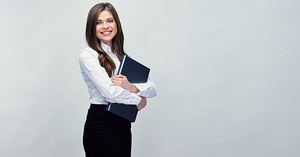 Professionally dressed woman holding work binder